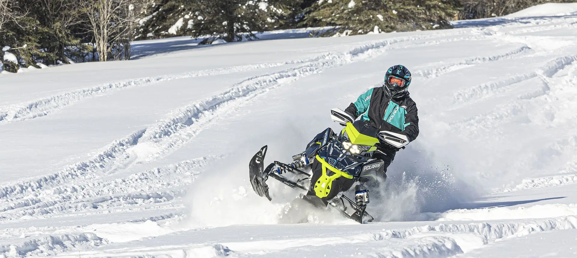 rider blasting through deep snow on a polaris switchback assault snowmobile