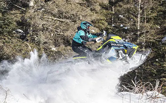 rider going airborne on a polaris switchback assault snowmobile