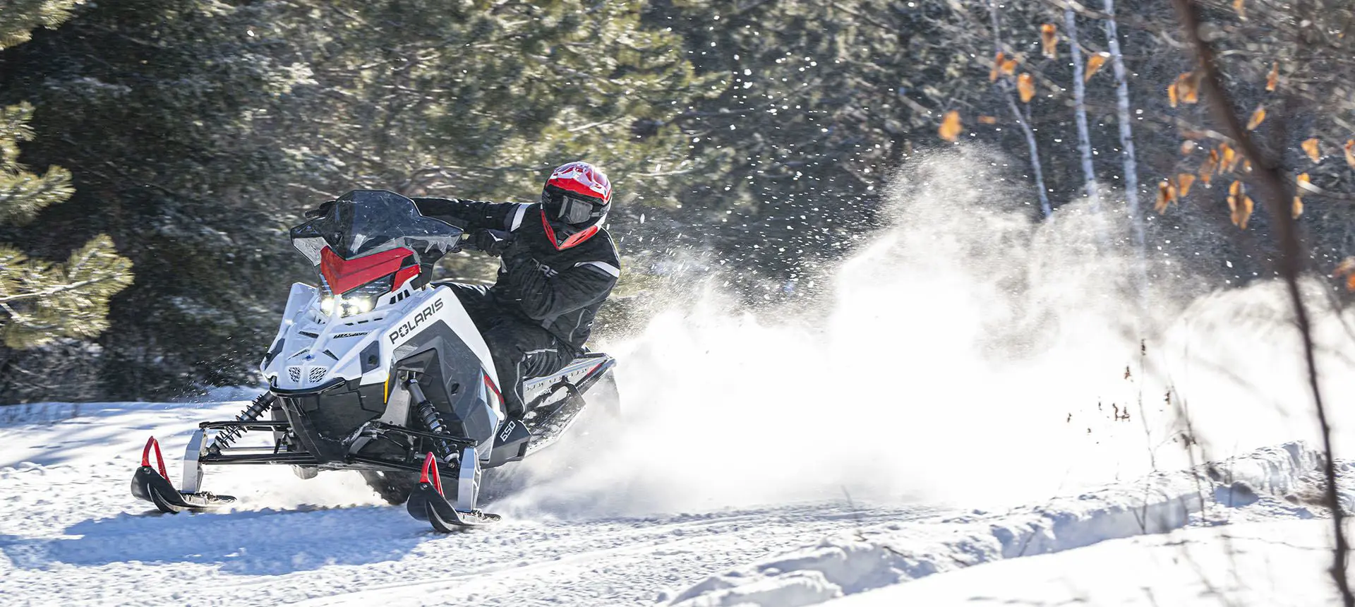 rider taking a tight turn on a polaris switchback sp snowmobile