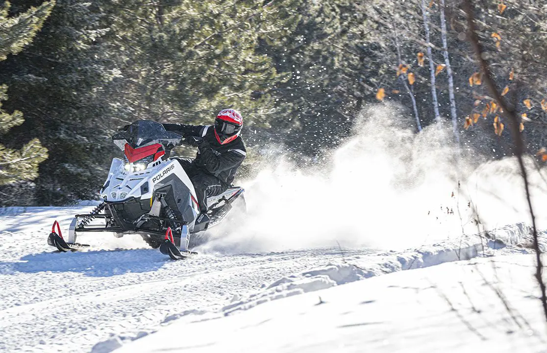 rider taking a tight turn on a polaris switchback sp snowmobile