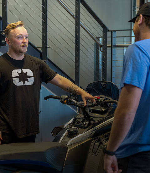 2 Polaris Product Pros discussing service needs for a Polaris Snowmobile.