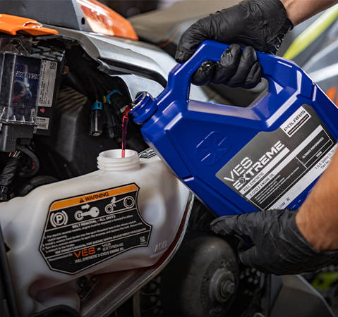 Oil lubricant getting poured into engine of a Polaris Snowmobile. 