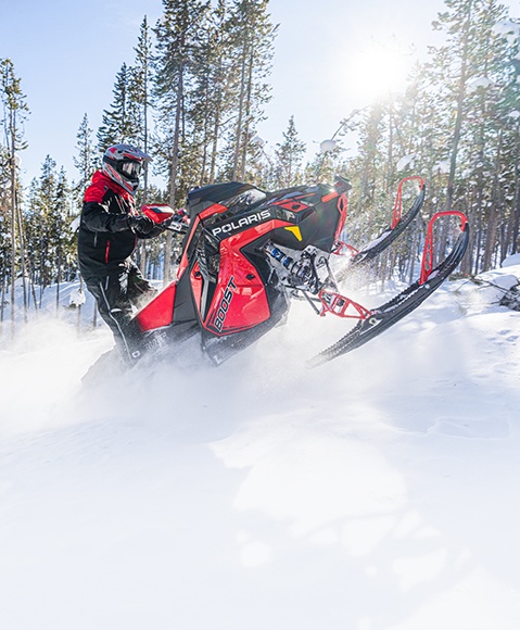 Rider getting lift on a 2026 Polaris Switchback crossover snowmobile.