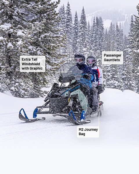 Extra Tall Windshield with Graphic, Passenger Gauntlets and M2 Journey Bag from the Trail Accessory Collection installed on a 2026 Polaris INDY Adventure snowmobile. 