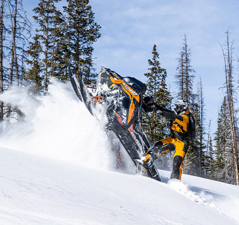 A rider showcasing the all-new 2026 Patriot 9R Polaris RMK Khaos 155 Limited Edition mountain snowmobile.