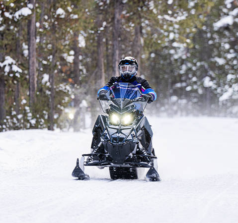 Front-end view showcasing the high-clearance A-Arms of a 2026 Polaris Voyageur SP 155 sport-utility snowmobile.