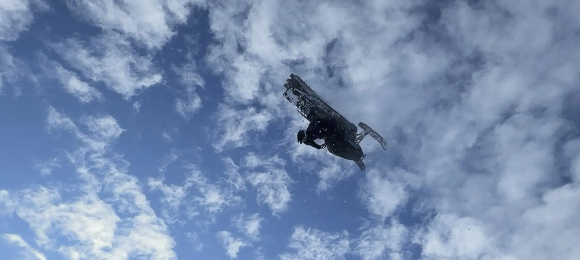Ty Desrochers performing an aerial stunt beneath a blue sky filled with clouds.