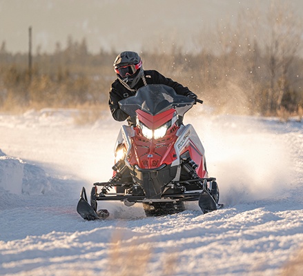 Rider on a 2027 Polaris INDY XC trail snowmobile showcasing the premium shocks.