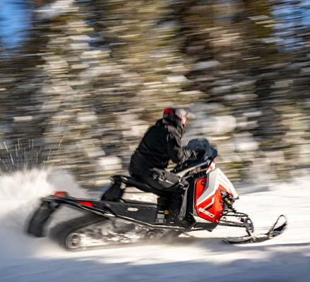 Rider on a 2027 Polaris INDY XC trail snowmobile showcasing the 1.35-inch Cobra track.