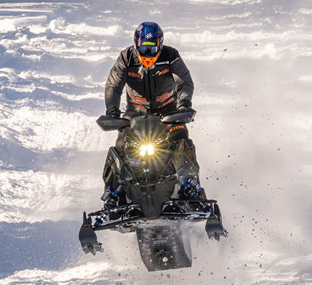 Rider on a 2027 Polaris INDY XCR snowmobile showcasing the built-in race technology.