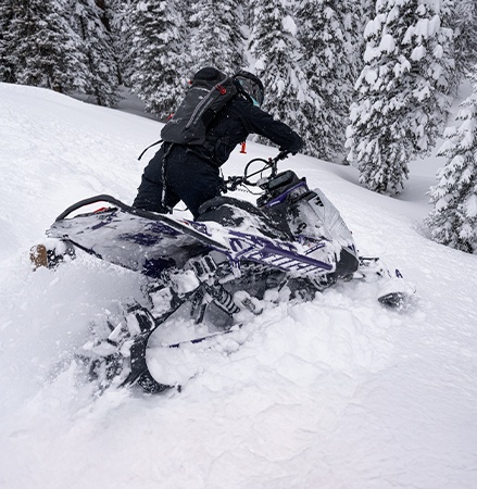 A rider showcasing the centralized cooling system on the 2027 Polaris Pro RMK mountain snowmobile.