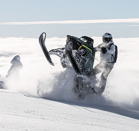 A rider showcasing the rigid chassis on a 2027 Polaris Pro RMK mountain snowmobile.