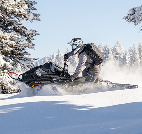 A rider showcasing the QuickDrive drive system featured on a 2027 Polaris Pro RMK mountain snowmobile.