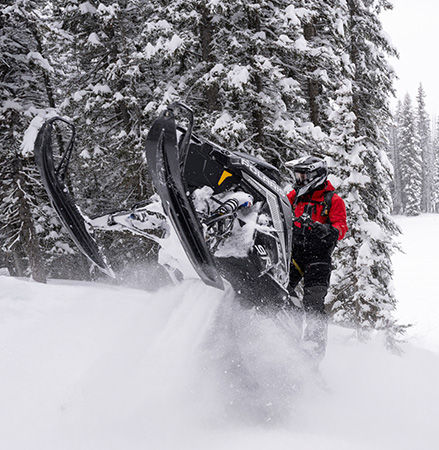 Rider showcasing the centralized cooling system on a 2027 Polaris RMK Factory Edition mountain snowmobile.