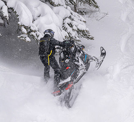 Rider showcasing the prevision-tuned setup of a 2027 Polaris RMK Factory Edition mountain snowmobile.