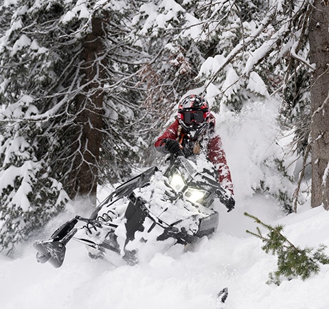 A rider showcasing the lightweight design of the 2027 Polaris RMK SPS mountain snowmobile.