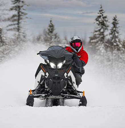 Rider on a 2027 Polaris Switchback SP snowmobile showcasing the 1.6-inch Cobra track.