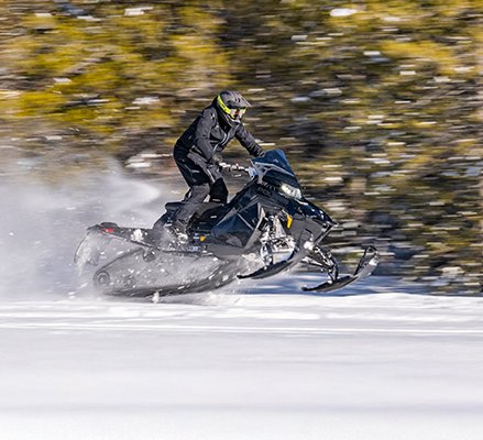 Rider showcasing the IGX 146 rear suspension on a 2027 Polaris Switchback XC crossover snowmobile.