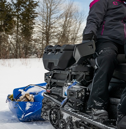 A 2027 Polaris TITAN Adventure Ultimate widetrack snowmobile pulling a sled with the standard tow hitch.