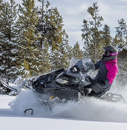 Rider on a 2027 Polaris Voyageur Adventure sport-utility snowmobile showcasing the high-clearance IFS.