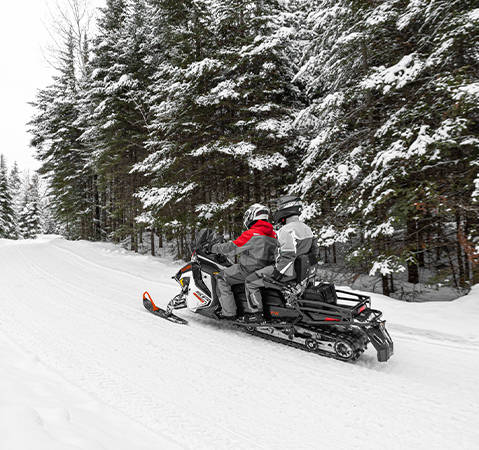 2 riders on a 2027 Polaris Voyageur SP 146 sport utility snowmobile showcasing the IGX 146 rear suspension.