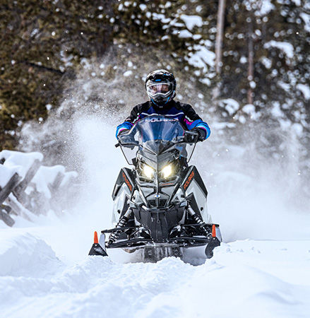 Rider on a 2027 Polaris Voyageur SP 155 sport-utility snowmobile showcasing the high-clearance IFS.