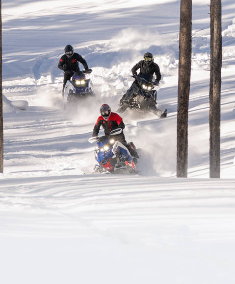 Rider getting lift on a 2026 Polaris Switchback crossover snowmobile.