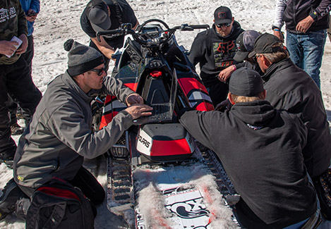 Team Roseau doing check-ups on a Polaris Snowmobile