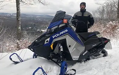 Adryan Pelosi next to a Snowmobile