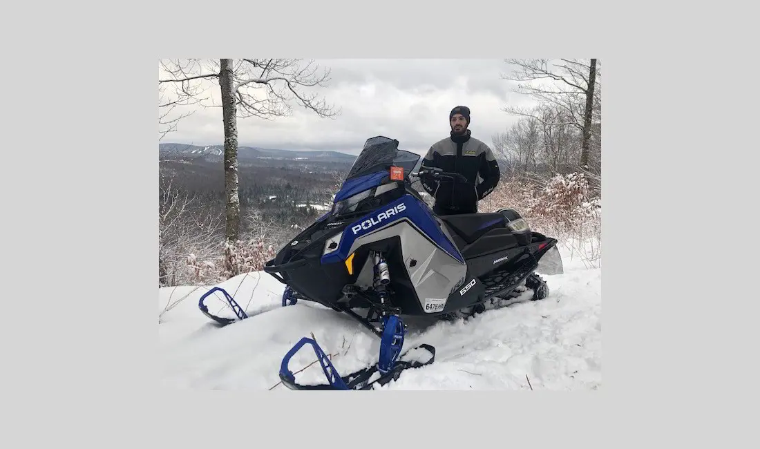 Adryan Pelosi next to a Snowmobile