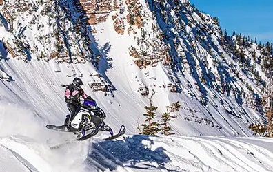 Gracie Gear riding a Snowmobile