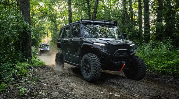 Rear view of a Midnight Blue 2025 Polaris XPEDITION ADV 5 side-by-side on a dusty trail.