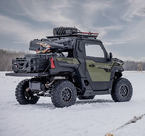 Two hunters walking back to their 2025 Polaris XPEDITION XP side-by-side in the winter.