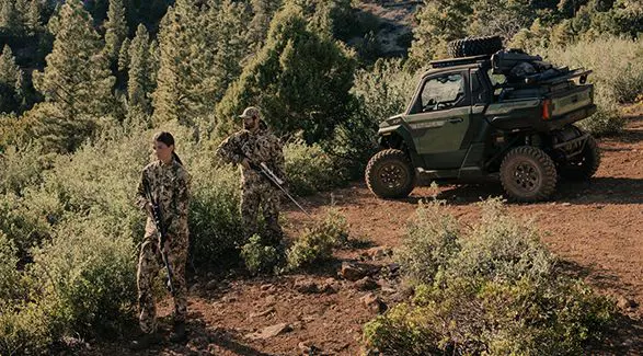 2 hunters walking away from their 2025 Polaris XPEDITION XP NorthStar side-by-side.