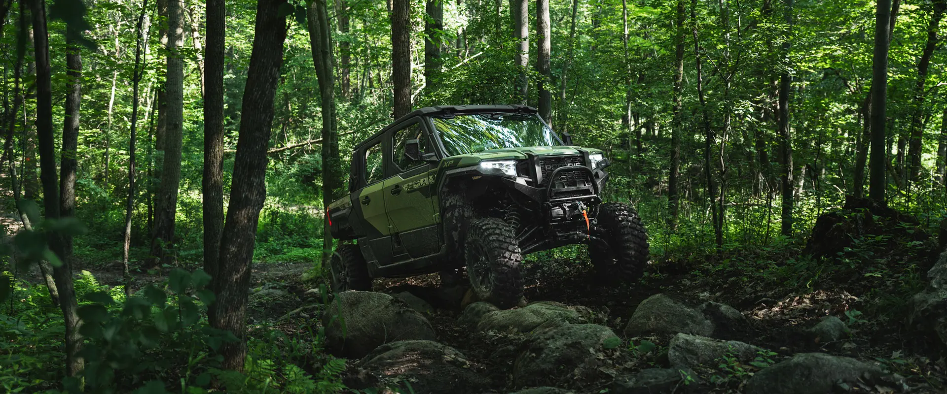 Front view of a 2025 Polaris XPEDITION XP 5 side-by-side cornering on a dusty trail.