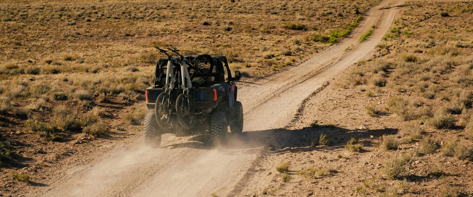 A family sitting around the campfire near their 2025 Polaris XPEDITION XP 5 side-by-side.