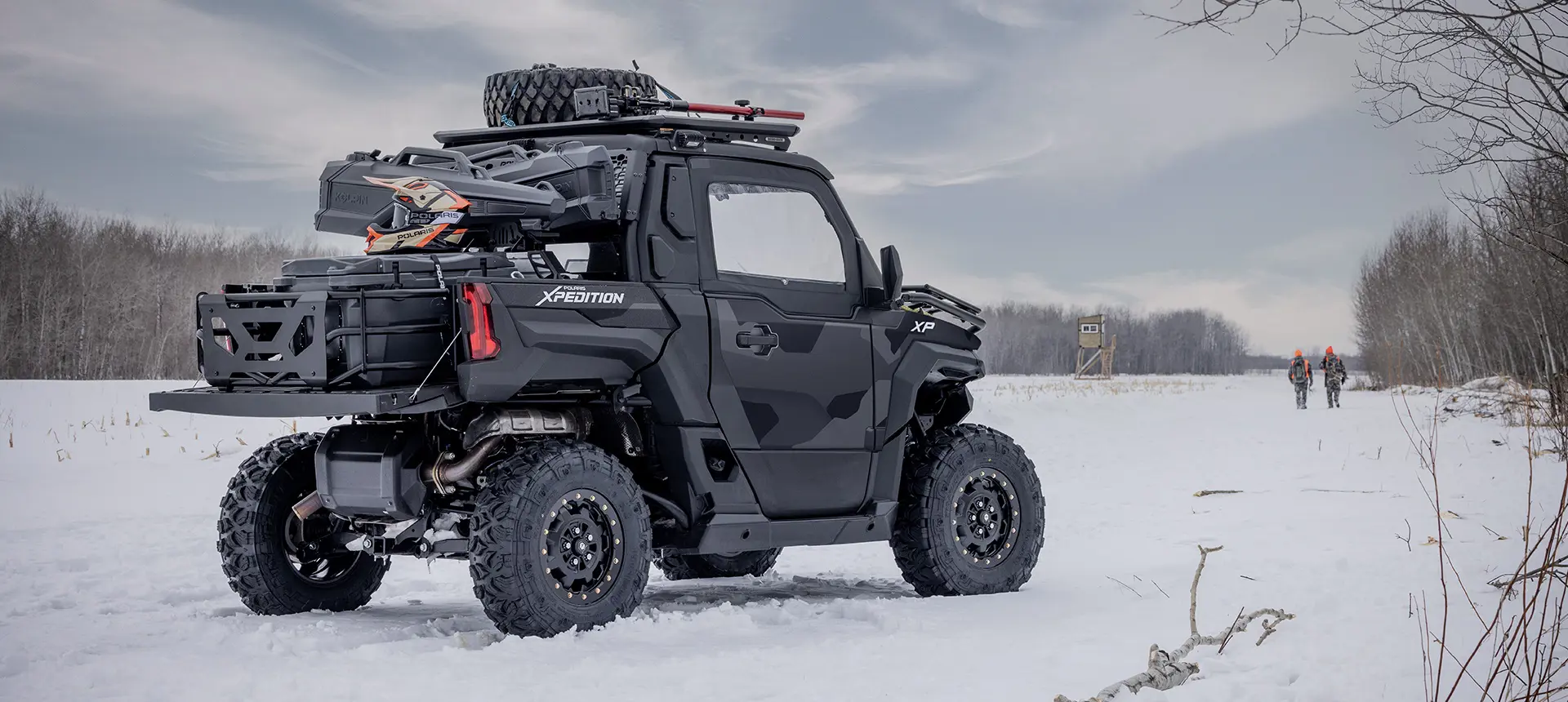 Side profile of a 2026 Polaris XPEDITION XP NorthStar side-by-side with 2 hunters walking away in the background.