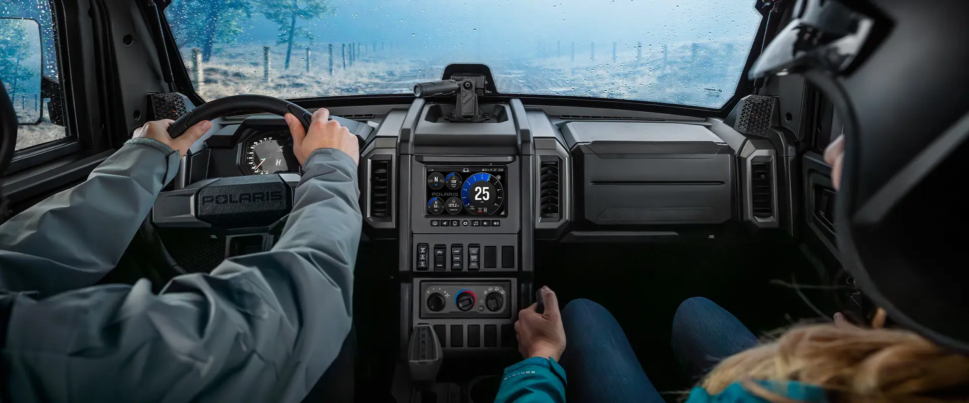 2 people inside of the all-season cab of a 2026 Polaris XPEDITION ADV NorthStar performance side-by-side.