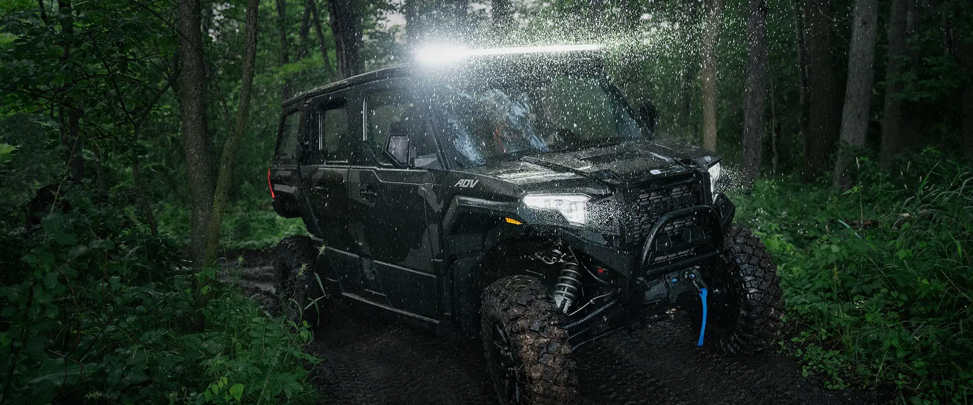 A 2026 Polaris XPEDITION ADV NorthStar performance side-by-side with lights illuminated and traveling at night.