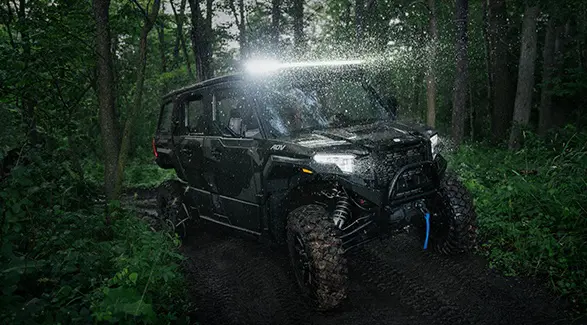 A 2026 Polaris XPEDITION ADV NorthStar performance side-by-side with lights illuminated and traveling at night.