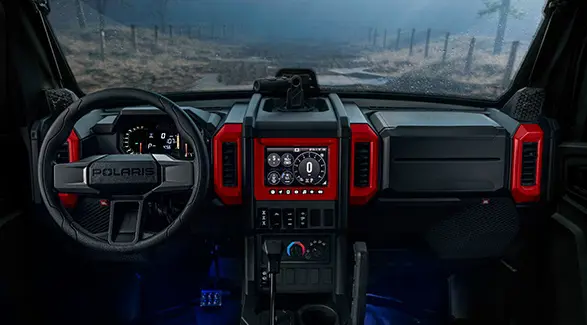 Interior view of the cab with red accents of a 2026 Polaris XPEDITION ADV NorthStar performance side-by-side.