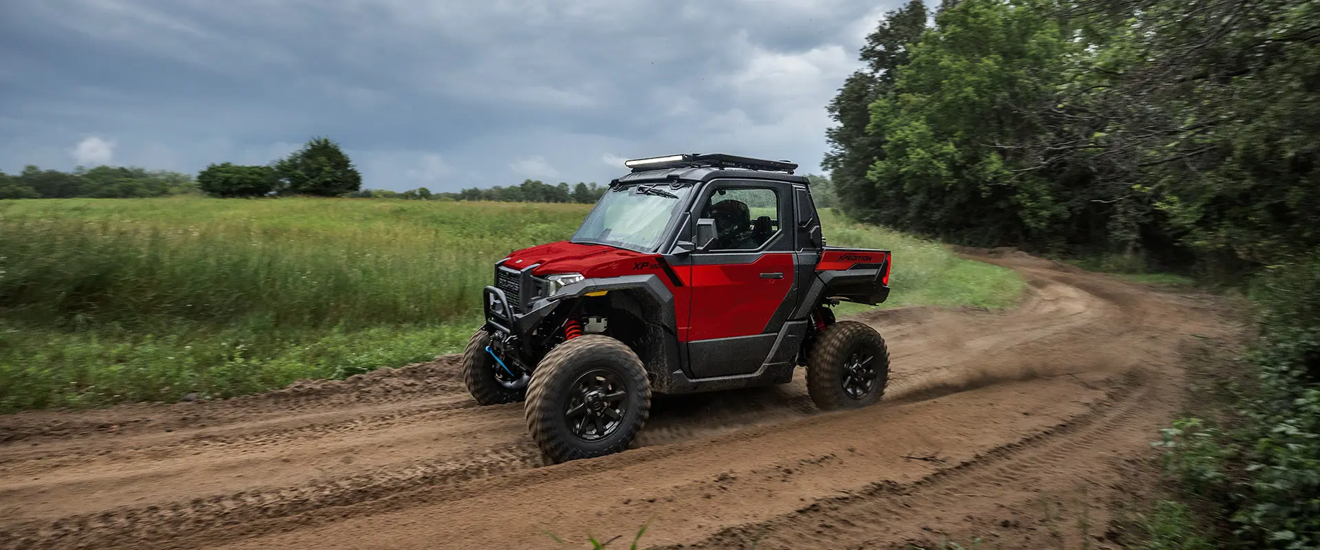 Perfil lateral de un Side-by-Side Polaris XPEDITION XP NorthStar de 2026 recorriendo un sendero.