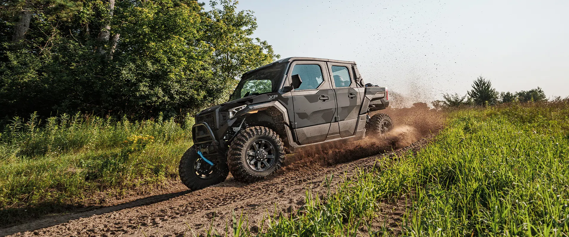 Side profile of a 2026 Polaris XPEDITION XP 5 NorthStar SxS throwing dirt on a trail.