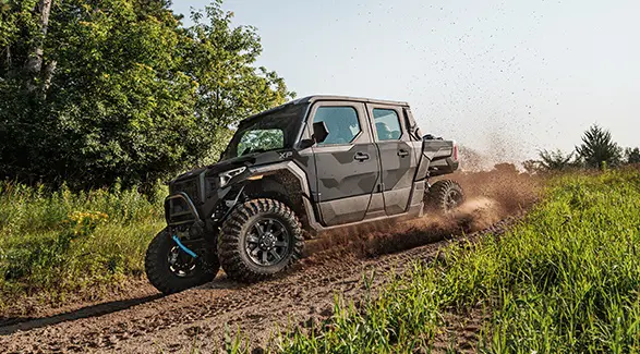 Side profile of a 2026 Polaris XPEDITION XP 5 NorthStar SxS throwing dirt on a trail.