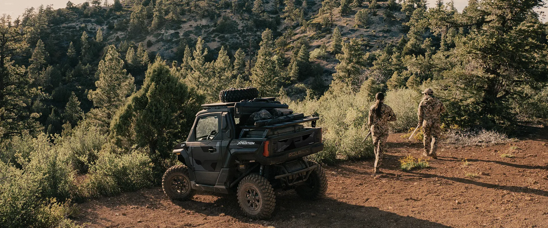 2 hunters walking away from a 2026 Polaris XPEDITION XP NorthStar performance SxS.
