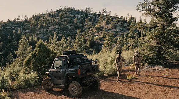 2 hunters walking away from a 2026 Polaris XPEDITION XP NorthStar performance SxS.