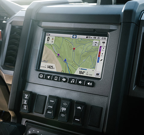 Interior of a Polaris XPEDITION side-by-side, showing the RIDE COMMAND display with a trail map and vehicle information, along with the steering wheel and dashboard.