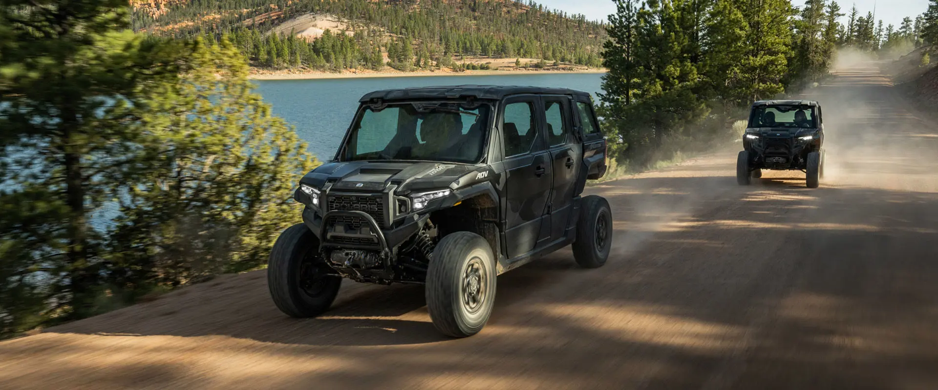 Two 2027 Polaris XPEDITION ADV NorthStar side-by-sides driving down a trail.