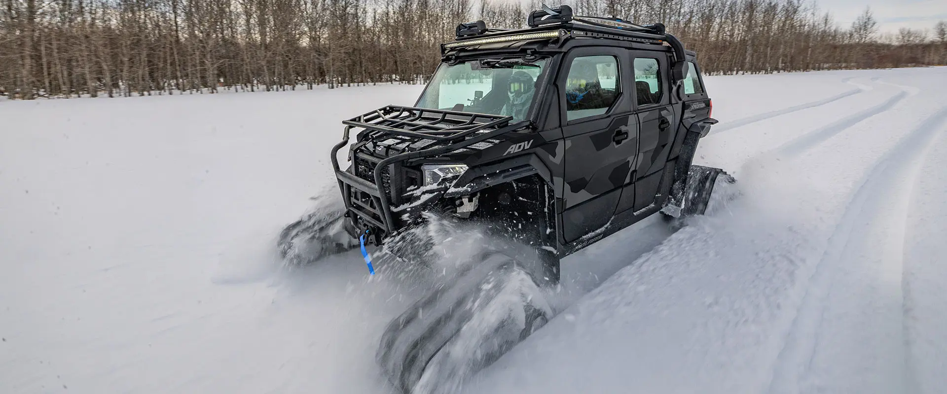 A 2027 Polaris XPEDITION ADV 5 NorthStar side-by-side with tracks driving through the snow.