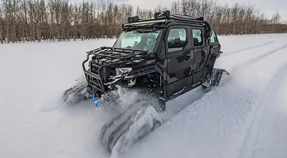 A 2027 Polaris XPEDITION ADV 5 NorthStar side-by-side with tracks driving through the snow.